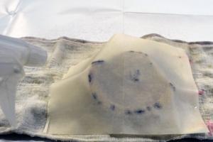 遺物に画仙紙を乗せ、水で濡らす画像